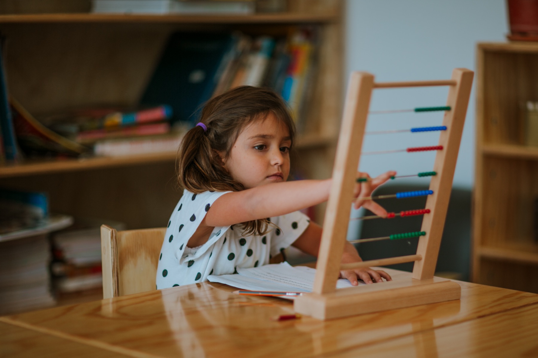 Niña explorando un ábaco Montessori