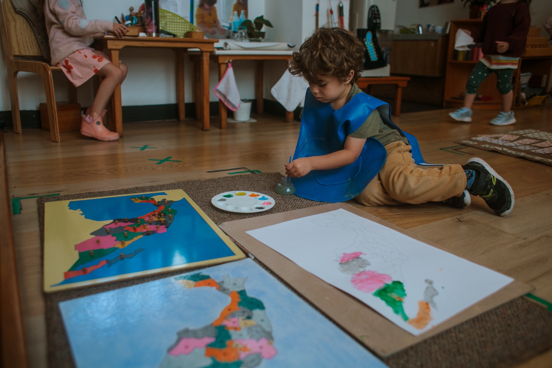 Niño trabajando concentrado con mapas Montessori